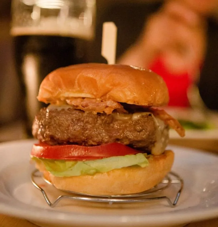 Stainless steel Burger Lift holding a burger above the plate